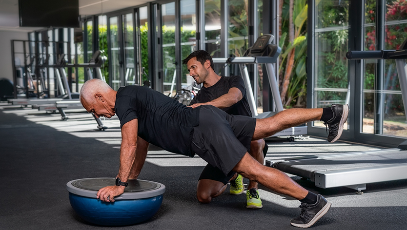 Elderly man exercising with a personal trainer